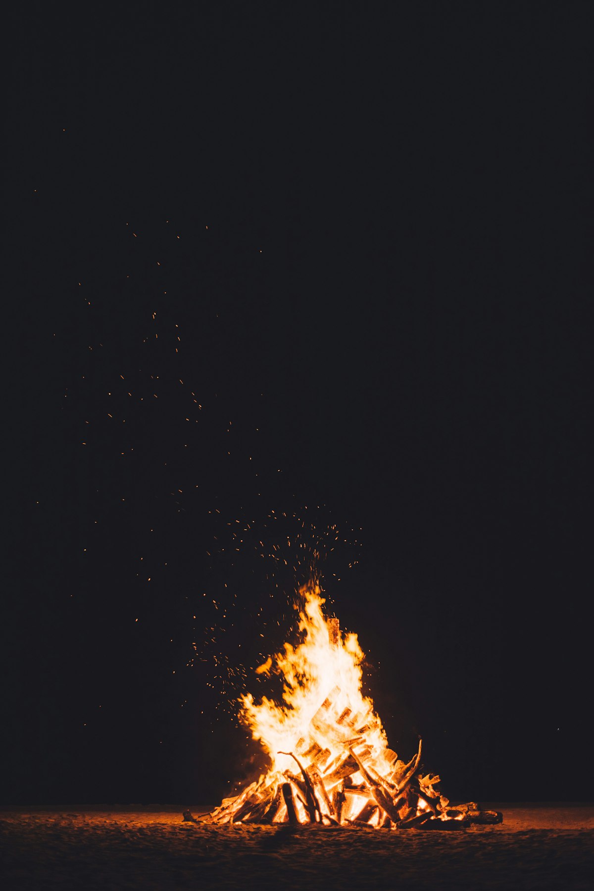 Evening fire in a round stone fire pit with glowing embers