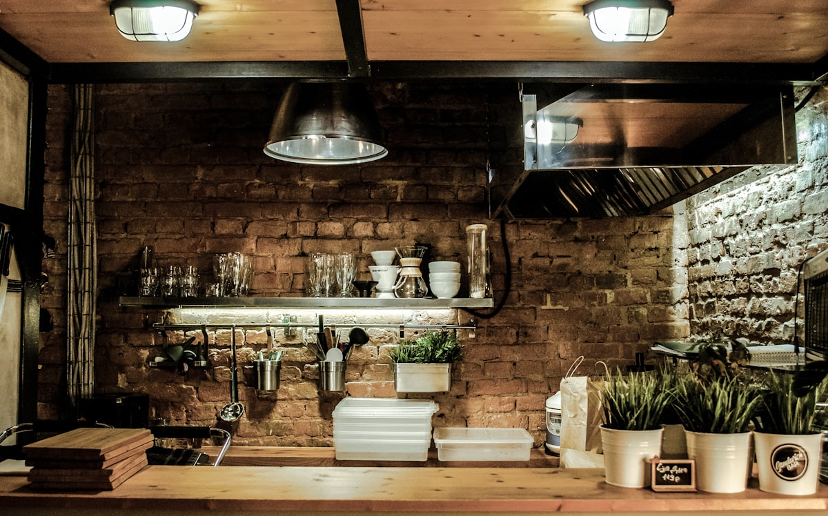 Outdoor bar and grill station with bar stools and landscape lighting